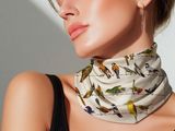 a woman wearing a neck scarf with birds on it