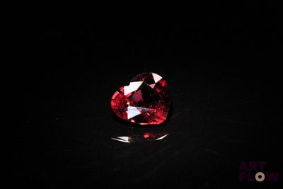 a close up of a red diamond on a black surface