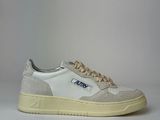 the white and blue sneakers are sitting on a white surface