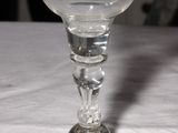 a wine glass sitting on a table with a cat in the background