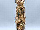une petite statue d'un homme avec un chapeau sur la tête