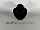 a close up of a necklace and bracelet on a mannequin