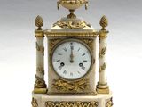 une horloge blanche et or posée sur une table