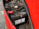 a red car that has a bunch of batteries in it