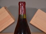 a bottle of wine sitting on a table next to a block of wood