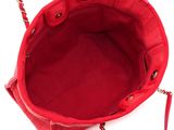 the red purse is sitting on a white surface with a chain around it
