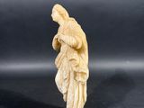 an antique carved ivory figurine of a woman holding a baby