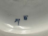 un gros plan d'un vase en porcelaine blanche orné d'un motif bleu et blanc