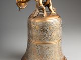 an antique brass bell with a bird on top of it