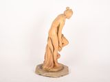 a wooden statue of a woman with a hat on her head