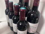 six bouteilles de vin rouge alignées sur une table