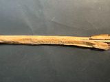 a wooden stick with a knife on it on a table