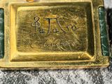 a close up of a gold plated watch with a green band