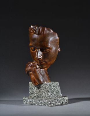 un buste en bronze représentant un homme, la main posée sur le menton