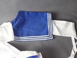 a blue and white uniform with white trims on a table