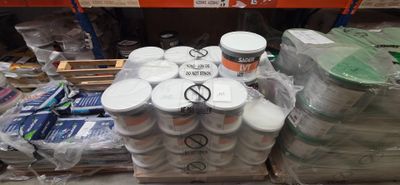de nombreux pots de peinture posés sur une palette dans un magasin