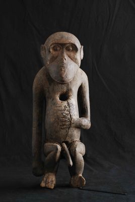 statue d'un singe assis sur un fond noir, avec un fond noir