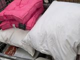 several pillows and pillows are stacked on top of each other in a store
