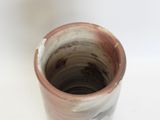 a close up of a brown and white vase on a table