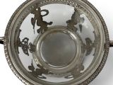 a silver bowl with a handle on a white surface