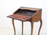 an old wooden writing desk with a small drawer on top of it