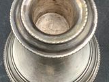 a silver vase that is sitting on a table