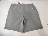 grey shorts on a white table with a pair of scissors on it