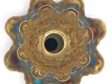 a close up of a gold and blue vase on a white surface