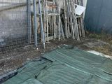 une bâche verte posée par terre devant une clôture