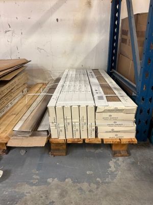 many stacks of boxes and pallets of wood in a warehouse