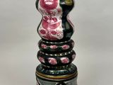 a black and pink vase sitting on top of a white table