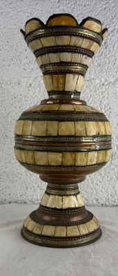 un vase posé sur une table, avec un mur blanc en arrière-plan