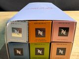 three boxes of coffee sit on a wooden table with a black background