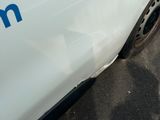 une voiture blanche avec un logo bleu sur le côté