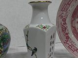 three vases sitting on a table with a plate in front of them