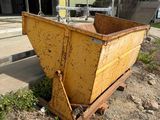 a yellow dumpster sitting on the ground in front of a building
