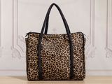 a leopard print handbag sitting on top of a wooden table