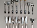 a lot of silver spoons and silverware on a table