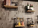 plusieurs étagères fixées au mur, sur lesquelles sont disposées des bouteilles et des vases