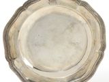 an antique silver plate on a stand on a white background