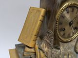 a gold clock with a statue of a man and a dog