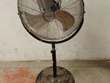 un ventilateur posé sur un support dans une pièce
