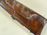 an old wooden rifle laying on top of a white surface