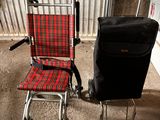 a red and black chair next to a black suitcase