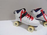 pair of white roller skates with blue and red laces on them