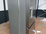 a silver refrigerator sitting on a pallet in a warehouse