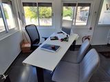 a table with chairs and a laptop on it in a room