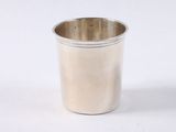 a silver cup that is sitting on a white surface