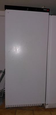 a white refrigerator in the corner of a kitchen
