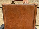 brown leather suitcase sitting on top of a black table